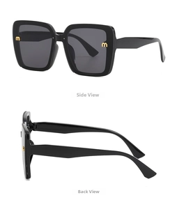 Detail of black oversized square sunglasses with gold metal m logo on the wide temple