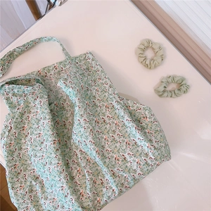 Floral cotton tote bag with matching green scrunchies shown in a flat lay perspective