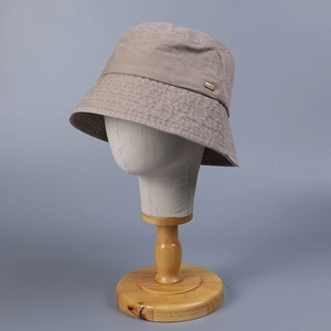 Unisex washed cotton bucket hat in khaki with stitched brim and metal logo accent