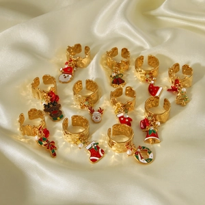 Christmas themed gold rings with charms like Santa, elk and trees on satin fabric