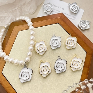 14k gold plated camellia flower pendant with white pearls on a wooden display tray