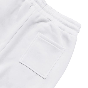 Detalle de la cintura elástica y el bolsillo trasero cuadrado en los pantalones de punto blancos