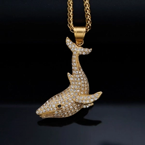Hip hop style gold-plated whale pendant necklace with shimmering crystals on black background