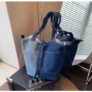 Detail of the blue denim patchwork tote bag with pocket showing material texture