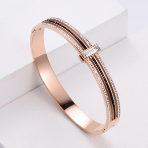 Rose gold stainless steel hinged bangle featuring sparkling black and white rhinestones