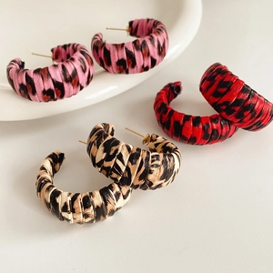 Three pairs of C-shaped leopard print earrings in pink red and brown textured leather