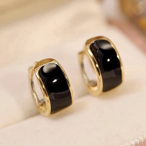 Minimalist gold hoop earrings with black enamel inlay in a velvet jewelry box