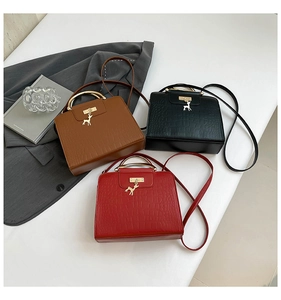 Trois sacs à main élégants avec texture croco et breloques de cerf doré en noir, marron, rouge