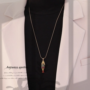 Detail of vintage koi fish pendant with colorful enamel on a gold sweater chain