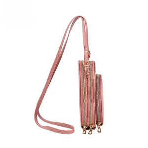 Detail view of pink crossbody bag with three zipper compartments and gold hardware