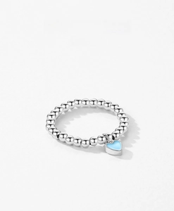 Macro detail of S925 sterling silver beaded ring with light blue enamel heart charm