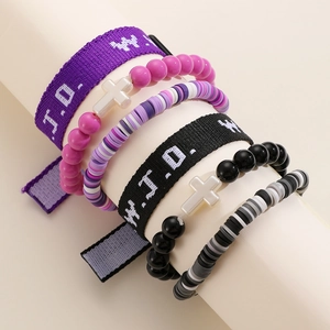 Detail of WWJD embroidered woven wristbands and colorful beaded bracelets with cross charms