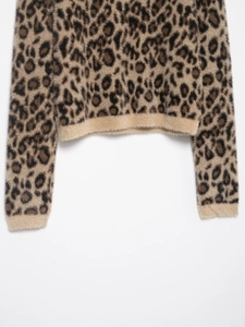Close-up of leopard print knit sweater showing hemline details and plush faux fur texture