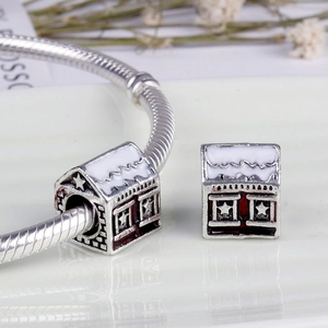 Silver house charm with white and red enamel details on a silver chain bracelet