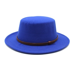 Détail du chapeau en laine bleu marine avec ruban tressé marron et boucle texturée
