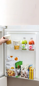 Detail view of transparent clip-on refrigerator organizers for side door bottle separation