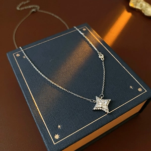 Collier avec pendentif étoile en argent et zircons sur une boîte à bijoux bleu marine