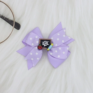 Detail of purple polka dot hair bow with Back to School ABC blackboard and apple charm