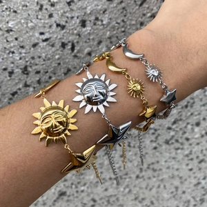 18k gold plated stainless steel star and moon charm bracelet on model's wrist