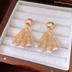 Detail view of 18K gold plated hollow mesh earrings with white pearl drops on jewelry box