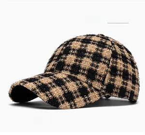 Close-up of khaki plaid tweed fabric texture and curved brim on a baseball cap