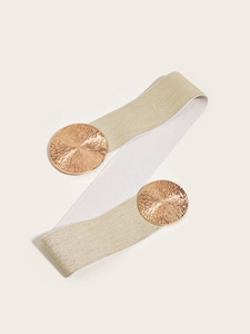 Close-up of golden elastic belt with large round metal buckles featuring sunburst texture