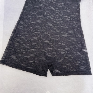 Détail du tissu en dentelle florale noire avec broderie ajourée sur le combishort