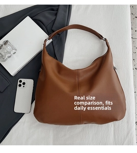 Braune Hobo-Tasche mit Lychee-Narbung im Größenvergleich mit Alltagsgegenständen