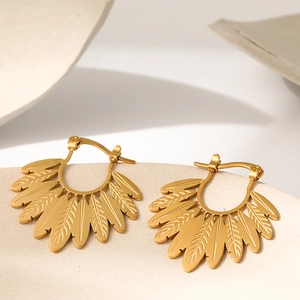 Minimalist gold hoop earrings featuring leaf shapes on a matte ceramic surface