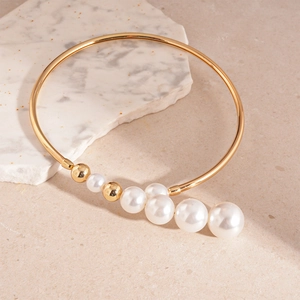 French vintage gold metal choker featuring gradient faux pearls on sandstone background