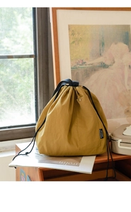 Detail of ginger yellow waterproof lunch bag with drawstring and side snap pocket
