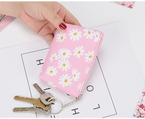 Close-up of pink daisy coin purse with smooth metal zipper and silver keychain attachment