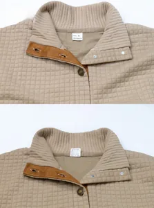 Close-up of beige quilted fabric with metal buttons and rib-knit collar detail