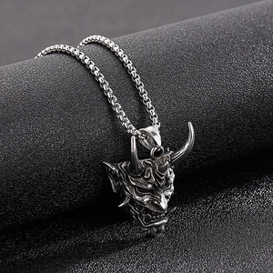 Detailed close-up of a vintage horned devil face pendant on a steel ball chain