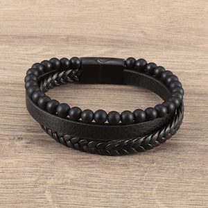 Pulsera multicapa para hombre con cuentas de lava y cuero trenzado sobre madera