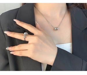 Detailed view of silver irregular pearl open ring and necklace on model