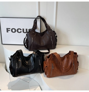Detailed view of large tote bags in brown, black, and caramel with side zippers