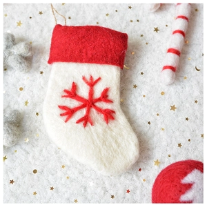 Detail of handmade wool felt Christmas stocking with red snowflake embroidery and sequins