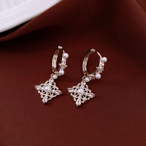 Détails de boucles d'oreilles losanges en or 18K avec perles et zircon sur velours