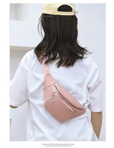 Rear view of model wearing a pink water-resistant waist bag with silver zippers