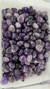 Macro view of 15mm polished heart-shaped amethyst natural crystal stones in bulk
