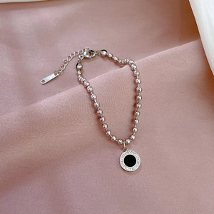 Detail showing silver bead chain bracelet with black agate pendant and sparkling rhinestones