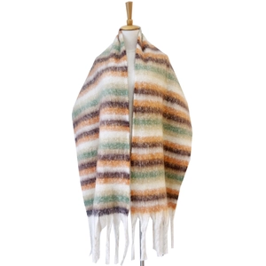 Detailed view of thick knit striped scarf featuring long white tassels and bouclé yarn texture