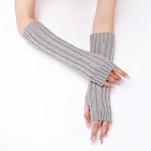 Detailed cable knit texture on grey fingerless arm warmers shown on a model