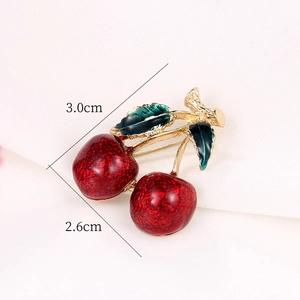 Detail view of red cherry brooch with enamel finish and gold leaves, size 3.0cm x 2.6cm