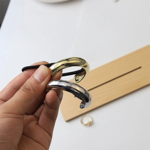 Close-up of sleek gold and silver alloy hair ties with polished metallic finish