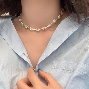 Elegant pearl flower necklace for women shown on a model wearing a light blue shirt