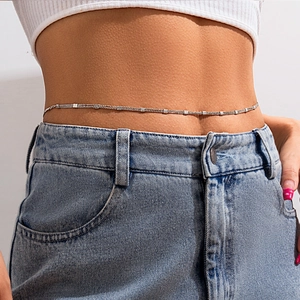 Close-up of triple-layered silver chain waist belt with small square metallic charms