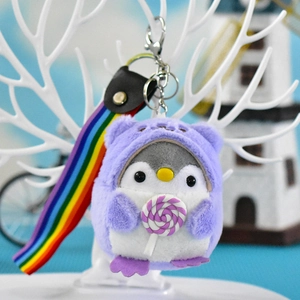 Nahaufnahme eines niedlichen lila Plüsch-Pinguin-Schlüsselanhängers mit Regenbogenband