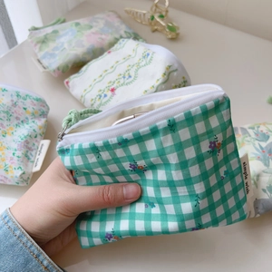 Gros plan sur petit porte-monnaie en coton à imprimé feuillage et étiquette tissée